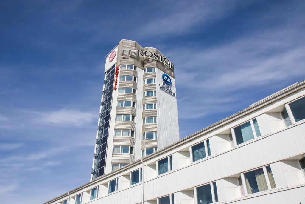 Un grand bâtiment avec un panneau en haut dans l'établissement Best Western Eurostop Orebro, à Örebro