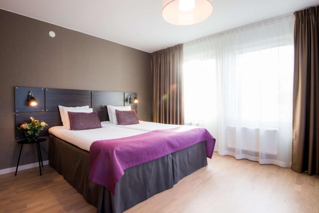 a hotel room with a large bed and a large window at Best Western Plus Park Airport Hotel in Arlanda
