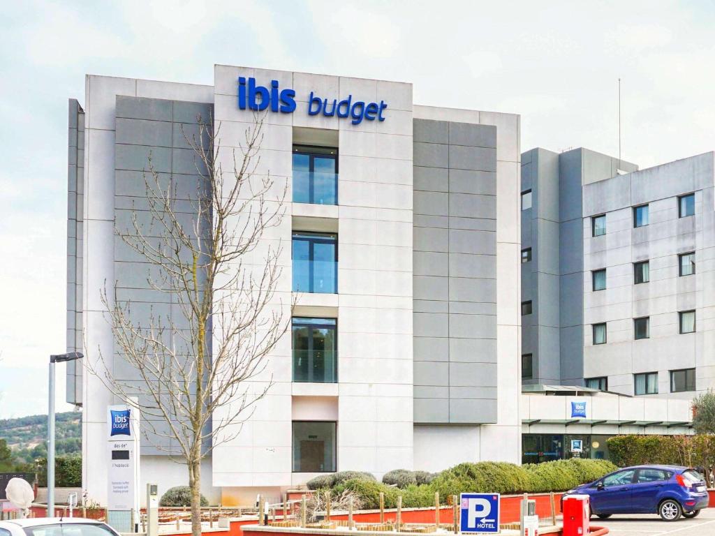 un edificio con un letrero de cubo de trabajo en él en Ibis Budget Girona Costa Brava, en Girona