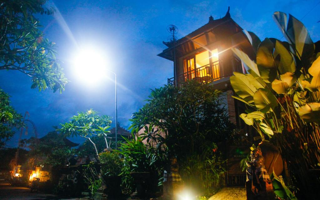 a street light next to a house at night at Baruna Guest House in Ubud