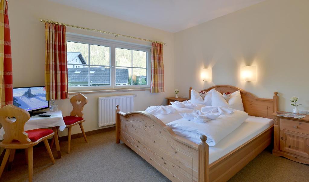 a bedroom with a bed and a desk with a computer at Posthotel Mayrhofen in Mayrhofen