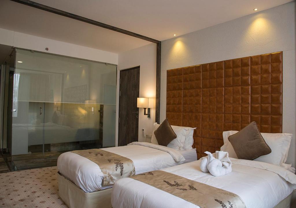 Postel nebo postele na pokoji v ubytování Regenta Central Hotel & Convention Centre Nagpur