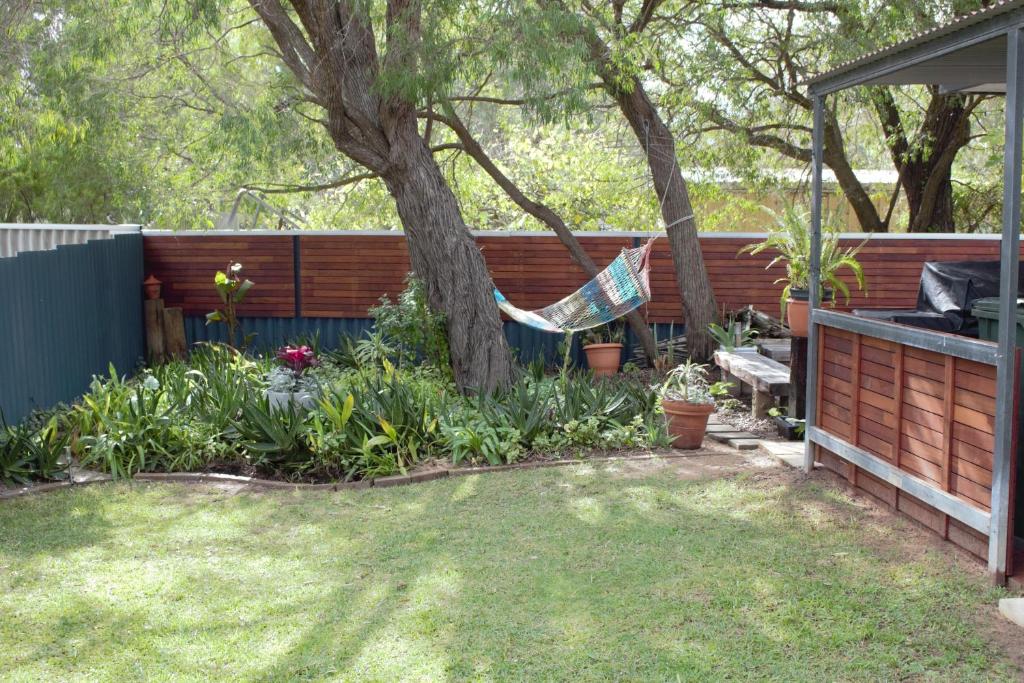 a hammock hanging from a tree in a garden at Abbey Beach Cottage in Busselton