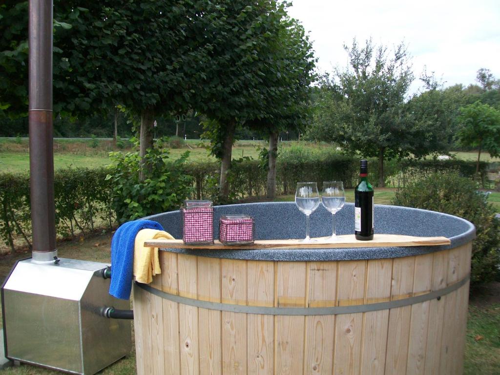 einen Whirlpool mit zwei Weingläsern und einer Flasche Wein in der Unterkunft Heidehof Pension B & B in Elten