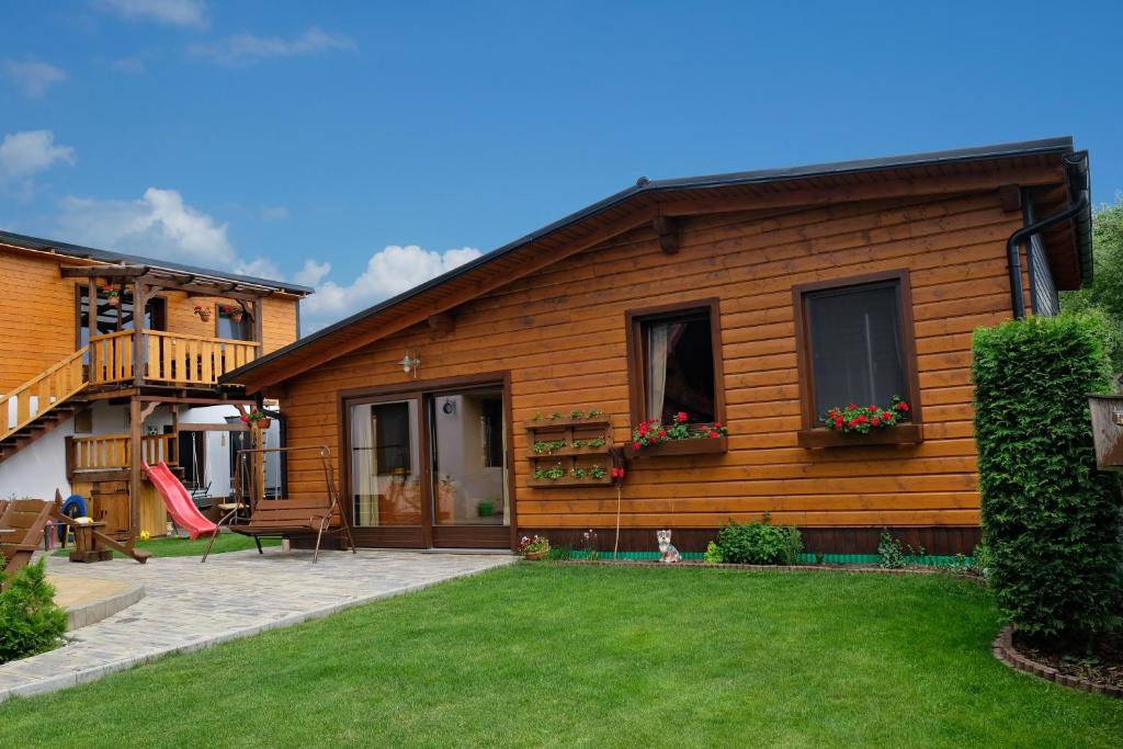 a wooden house with a yard in front of it at Drevený raj in Hrabušice