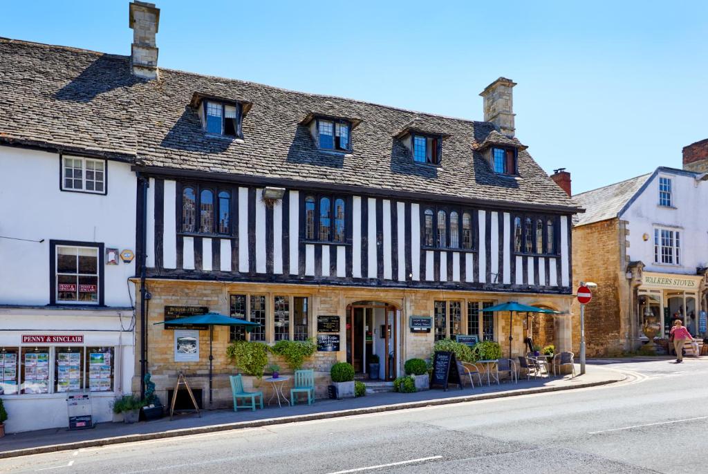 an old building with tables and chairs on a street at Burford House BH in Burford