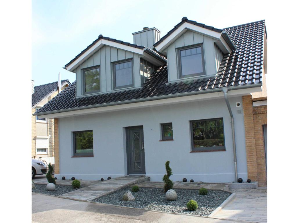 een wit huis met een zwart dak bij Befeld Susanne in Neustadt in Holstein