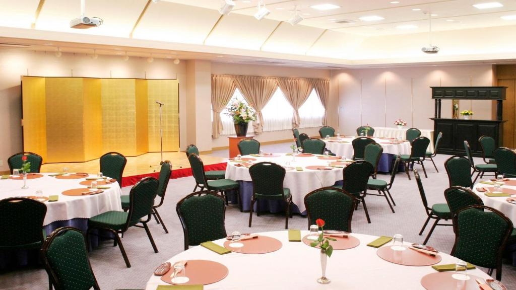 a conference room with tables and chairs and a projection screen at New Commander Hotel Osaka Neyagawa / Vacation STAY 1341 in Neyagawa