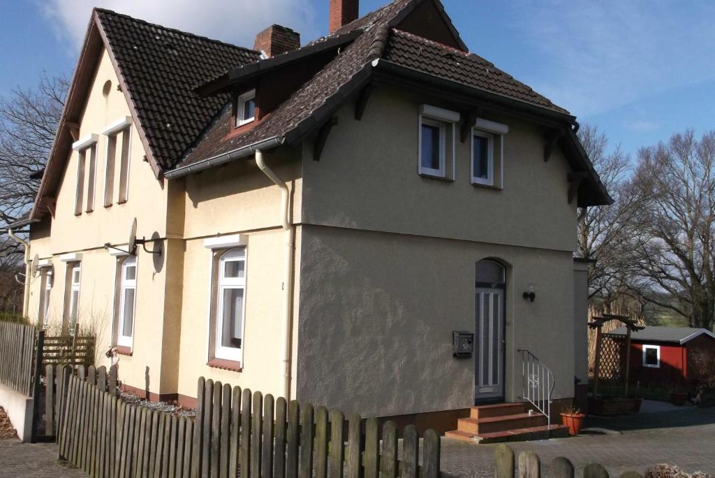 a yellow and white house with a wooden fence at Peper Ute in Neustadt in Holstein