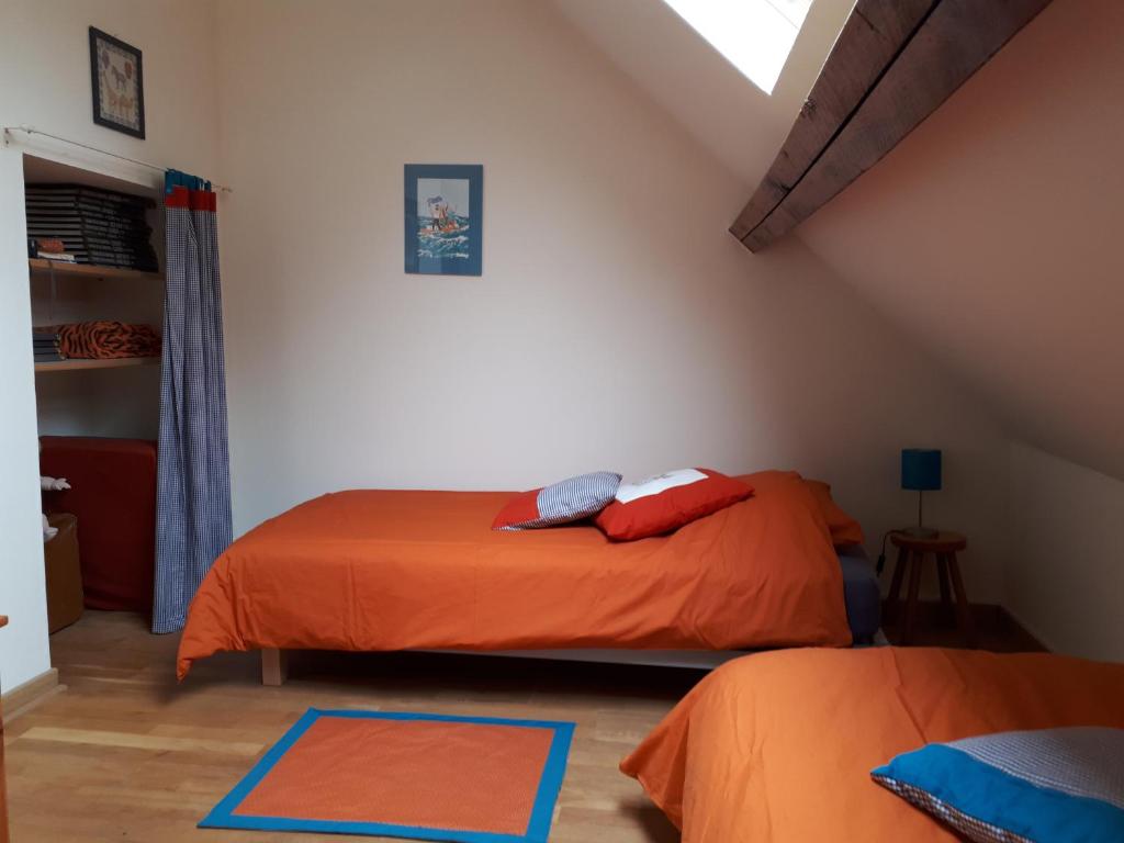 1 dormitorio con 2 camas con sábanas de color naranja en La Maison Brodée en Écaussinnes-dʼEnghien