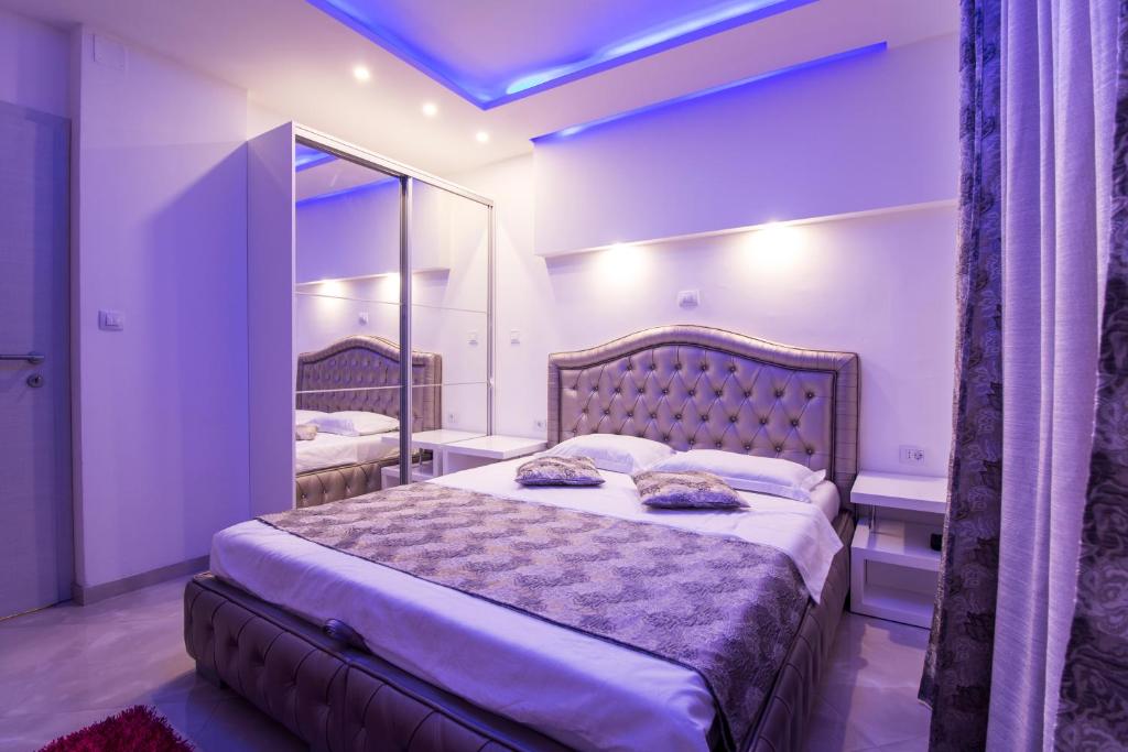 a bedroom with a large bed and a mirror at Apartman M.E.P. in Split