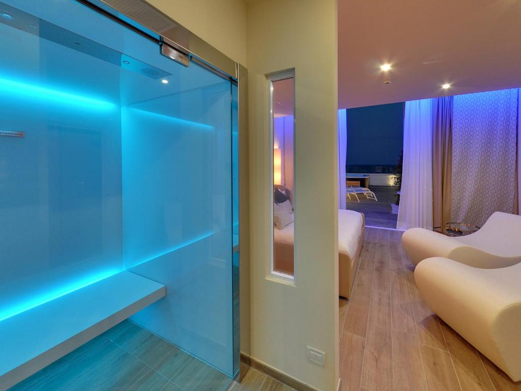 a room with a glass door and a bedroom at Hotel Montecarlo in Bibione