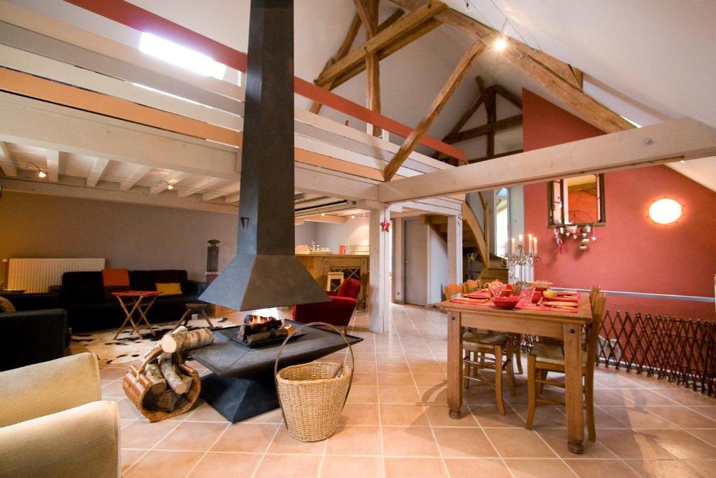 a living room with a stove in the middle of a room at Gite Le Meix Chapeau in Levernois