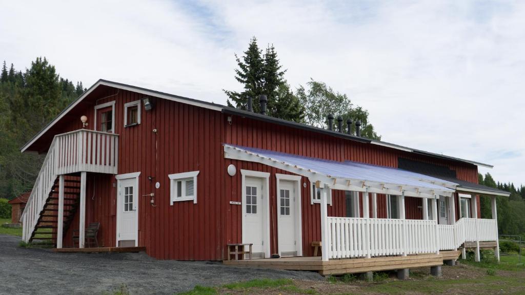 a red building with white doors and a porch at Paimentupa in Kolinkylä