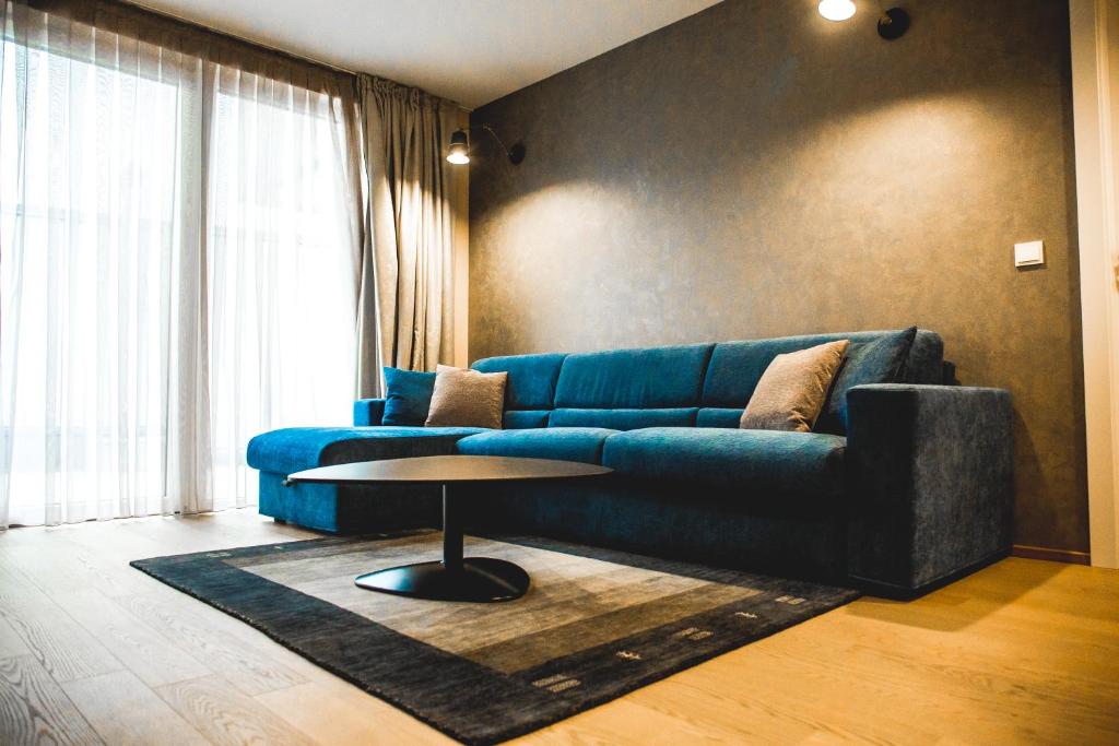 ein Wohnzimmer mit einem blauen Sofa und einem Tisch in der Unterkunft TOP LOCATION VIENNA MARIAHILF 9 in Wien