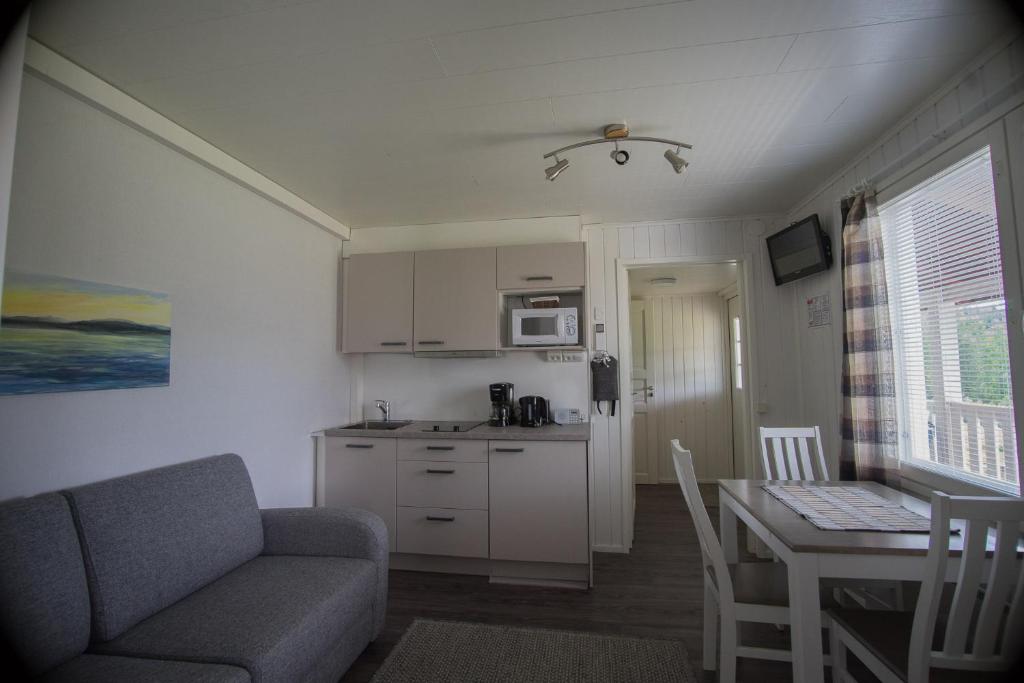 a kitchen and a living room with a couch and a table at Paimentupa in Kolinkylä
