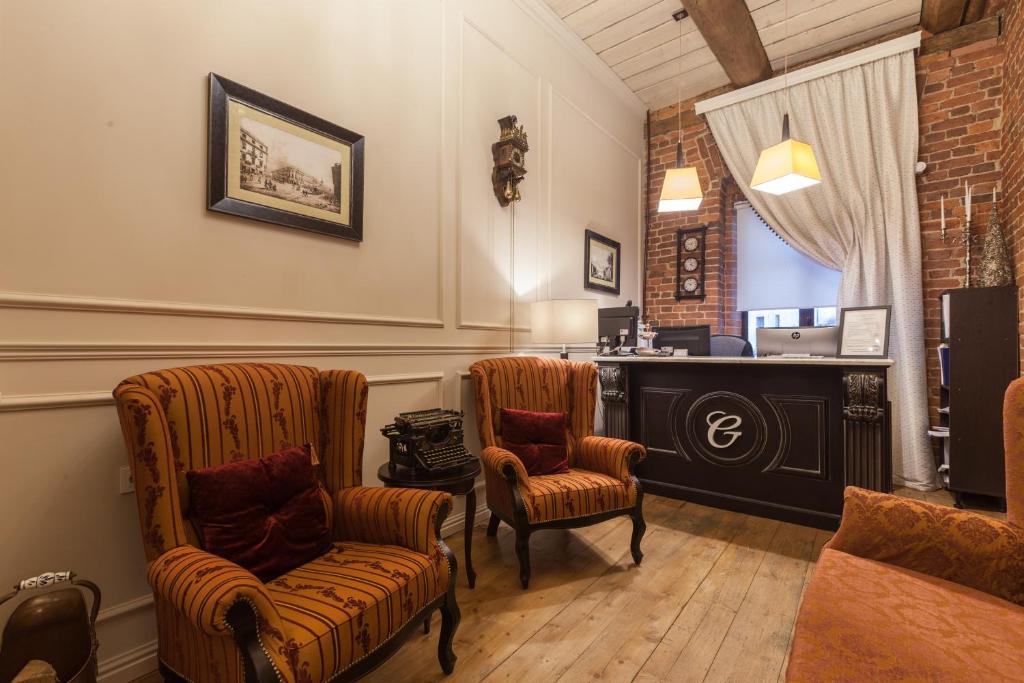 a living room with two chairs and a desk at Galunov Hotel in Saint Petersburg