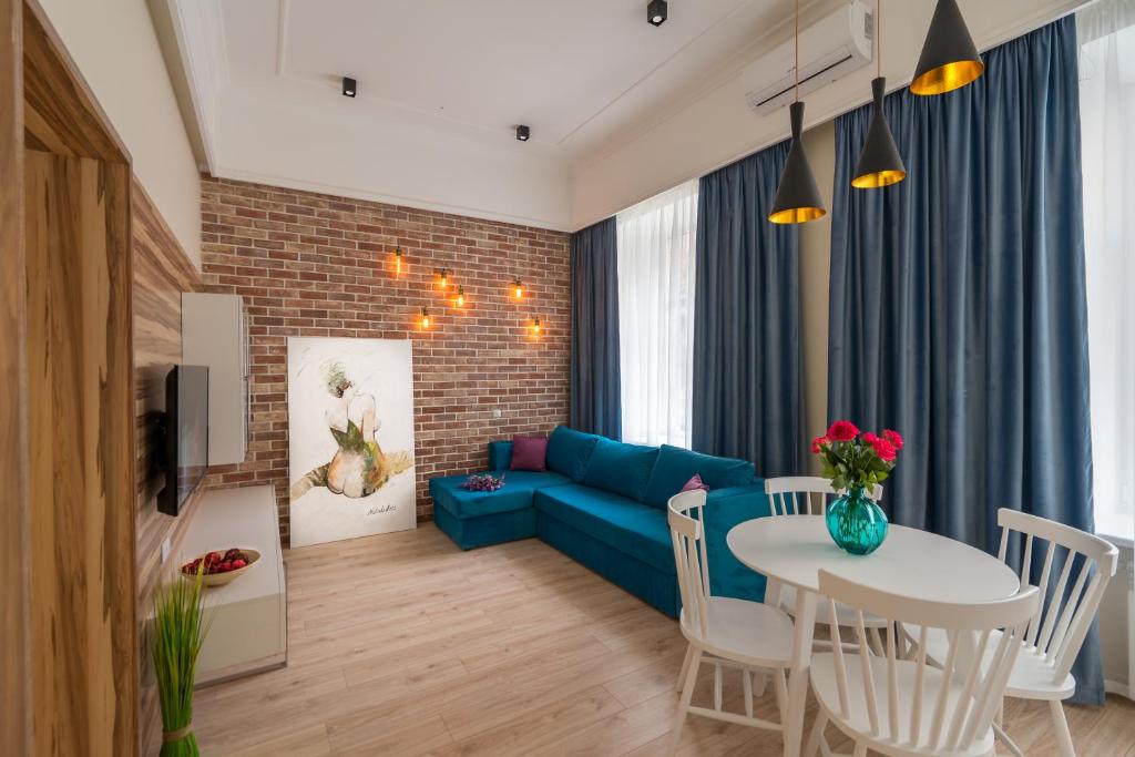 een woonkamer met een blauwe bank en een tafel bij Sofievskaya Apartments in Kiev