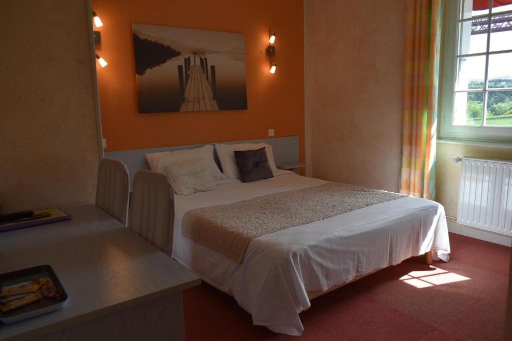 a bedroom with a large bed in a room at Logis Hôtel Beau Site in Loubaresse