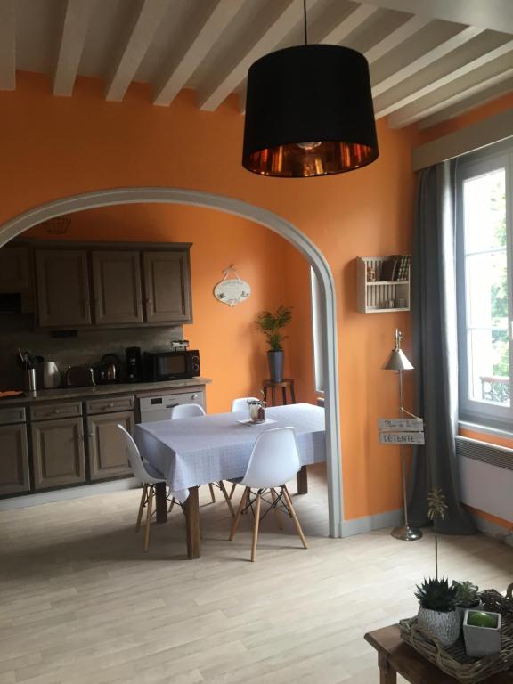 uma sala de jantar com uma mesa branca e uma janela em Appartement de L'Escale em Honfleur