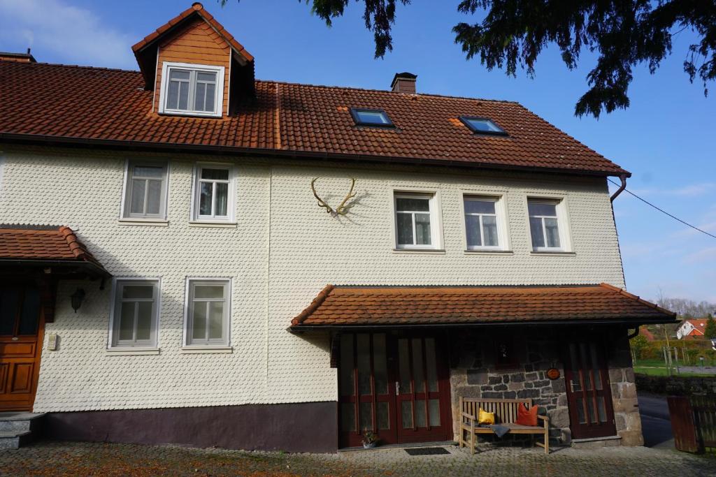 a white house with a red roof at Ferienwohnung Altes Forsthaus Hella in Grebenhain