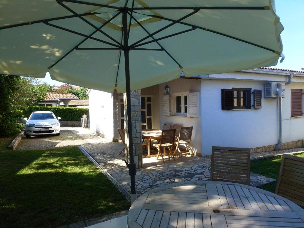 a patio with a table and a large umbrella at Apartments Mladen in Njivice