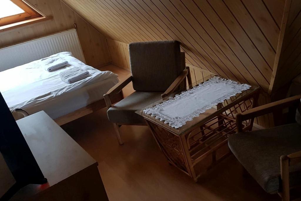 a attic room with a chair and a bed at Willa Końiczynka in Zakopane