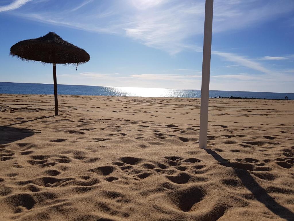 クアルテイラにあるSolimmoの砂浜の海辺の傘2本