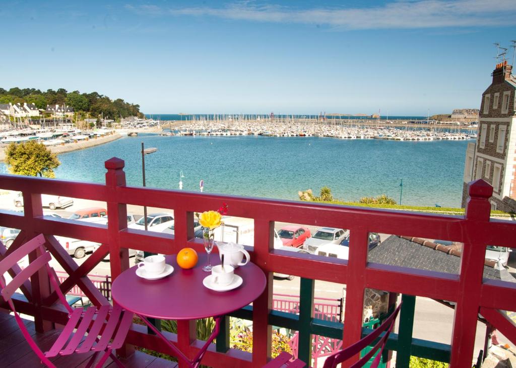 Czerwony balkon ze stołem i krzesłami oraz plażą w obiekcie Manoir Du Cunningham w Saint-Malo