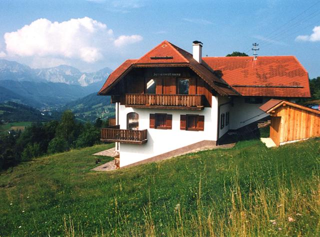una casa en la cima de una colina con un campo verde en Ferienwohnung Christine Spiessberger, en Gmundnerberg
