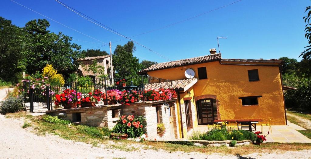 una casa con flores a un lado. en B&B Bosimano, en Arcevia