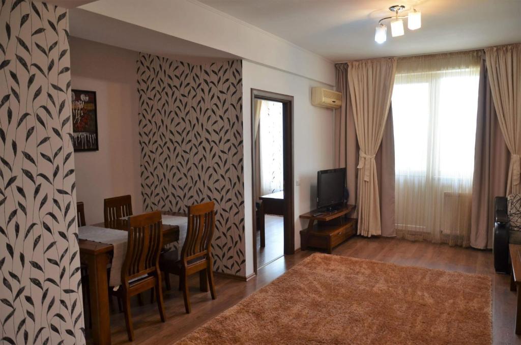 a living room with a table and a dining room at Denis Summer in Mamaia