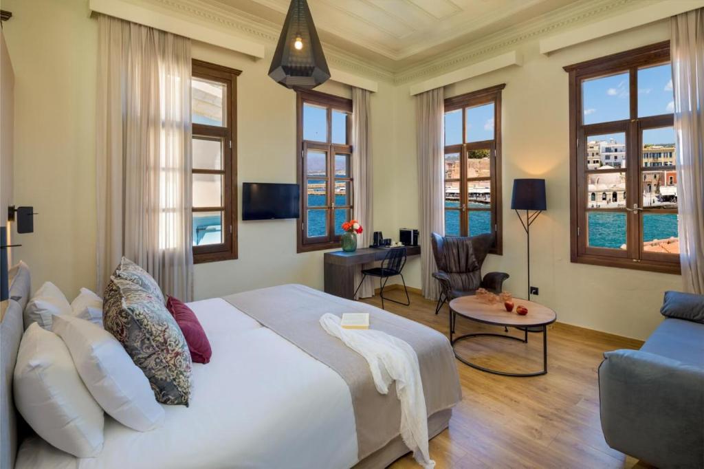 a bedroom with a large white bed and a couch at ELG Contessa Boutique Hotel in Chania Town