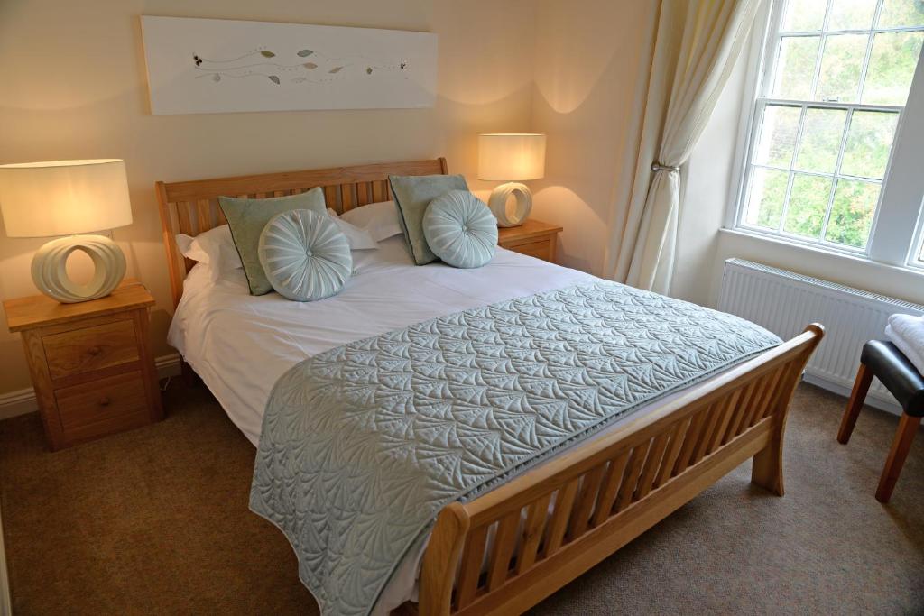 a bedroom with a large bed with blue pillows at The Foresters in Frome