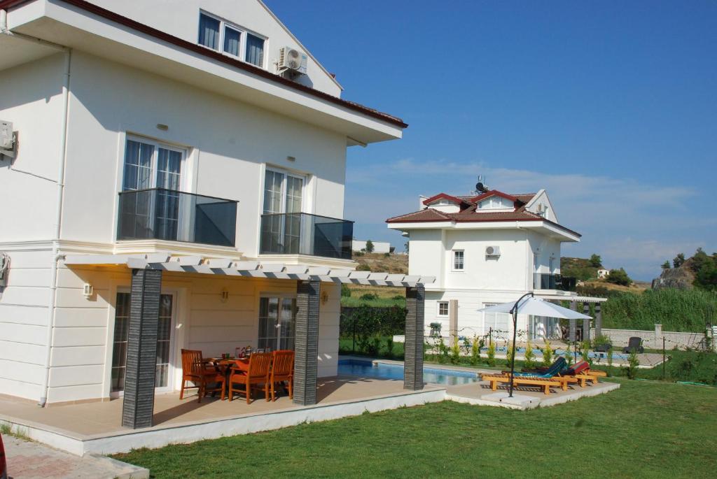 a white house with a patio and a swimming pool at Villa Arance in Fethiye