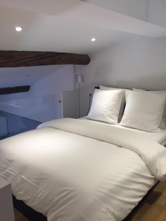 a large white bed with white sheets and pillows at Le cap in Menton