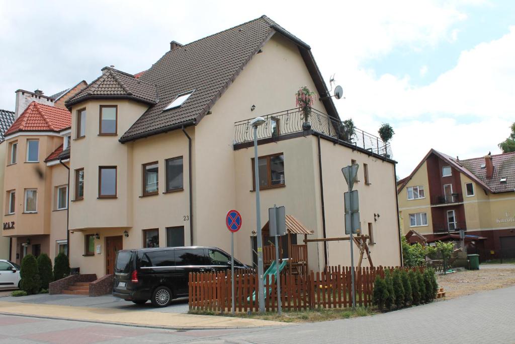 a house with a car parked in front of it at Pokoje Gościnne Magdalena in Dziwnówek