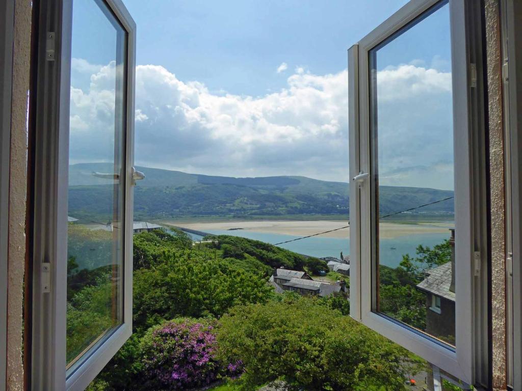 an open window with a view of the water at Bryn Melyn Apartments in Barmouth