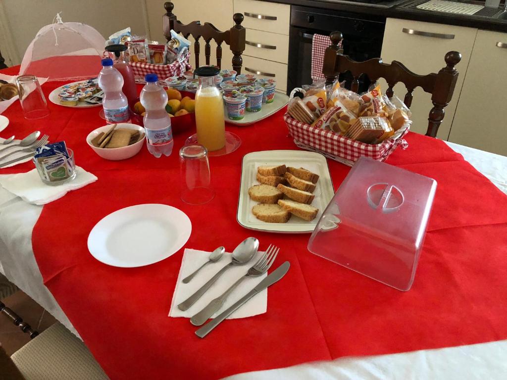 a table with a red table cloth with food and drinks at Villa Cenzina in Marina di Pisticci