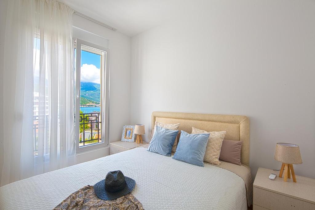 a bedroom with a large bed with a window at Chiron Apartments in Budva