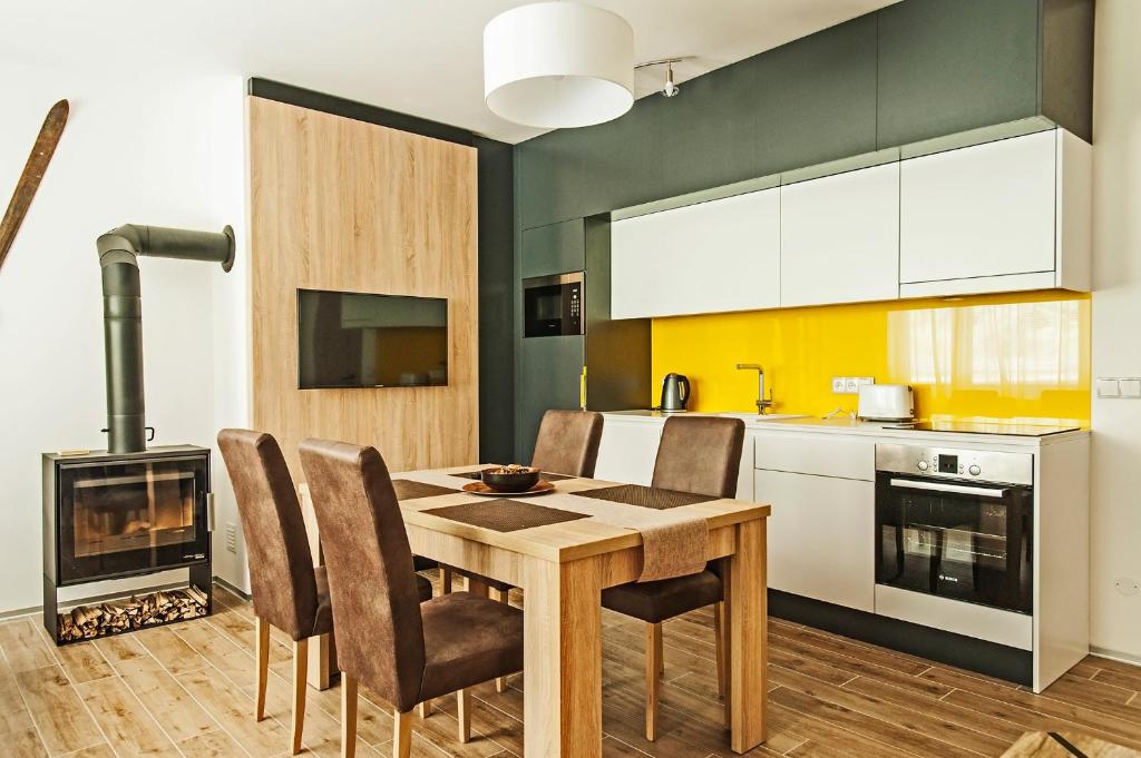 cocina con mesa, sillas y chimenea en The Fox Apartment, en Vrchlabí