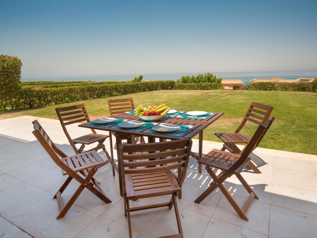 a table with chairs and a bowl of fruit on it at Luxury Chalet Telal in Ain Sokhna