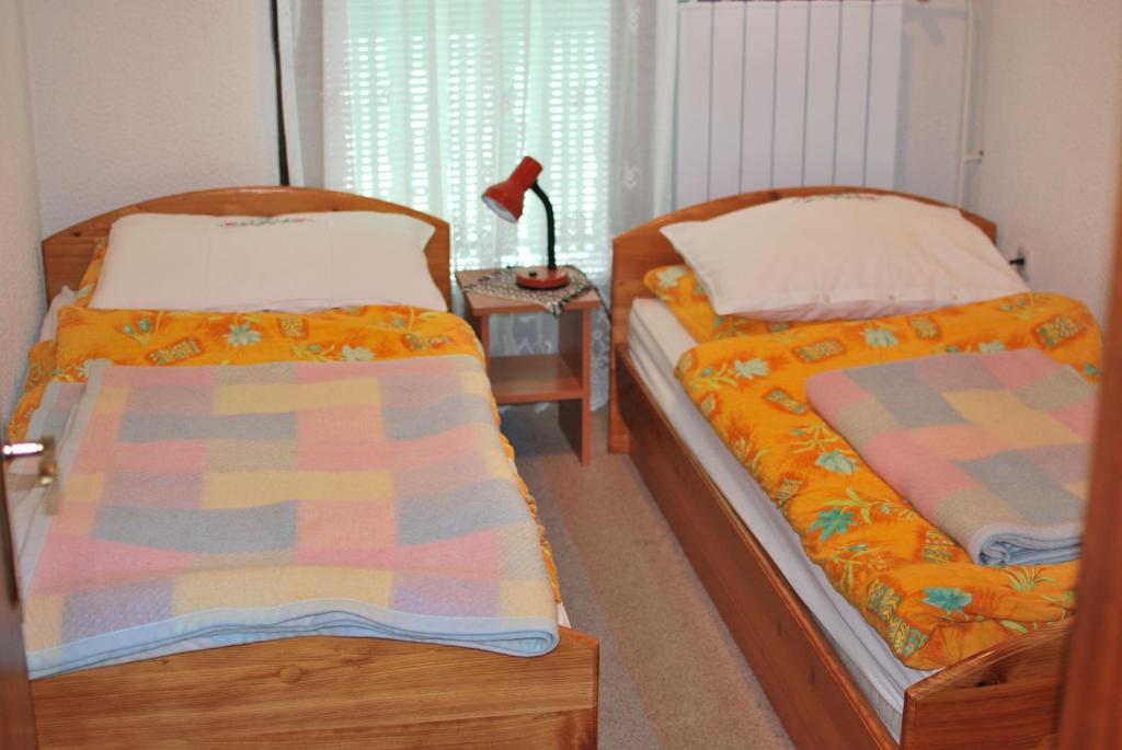 Duas camas num quarto com um candeeiro sobre uma mesa em Farm Stay Bogša em Ormoz