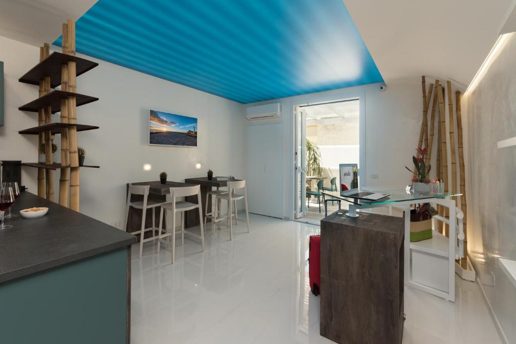 a kitchen with a blue ceiling and a dining room at Isule Rooms & Breakfast in San Vito lo Capo