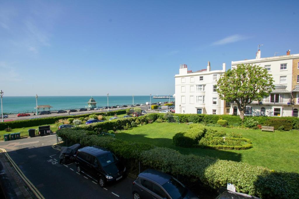 布萊頓霍夫的住宿－Regency Apartment - Sea View - by Brighton Holiday Lets，一条在大楼前停放汽车的街道