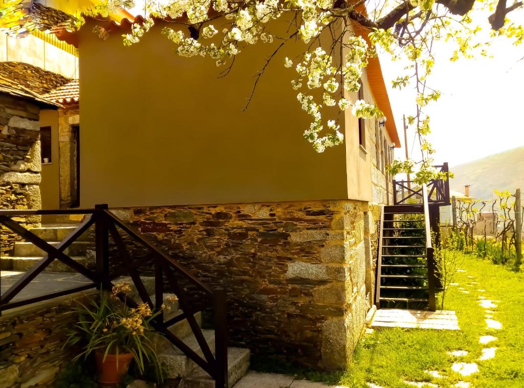 a building with a staircase and flowers on it at Casa do Lonho in Arouca