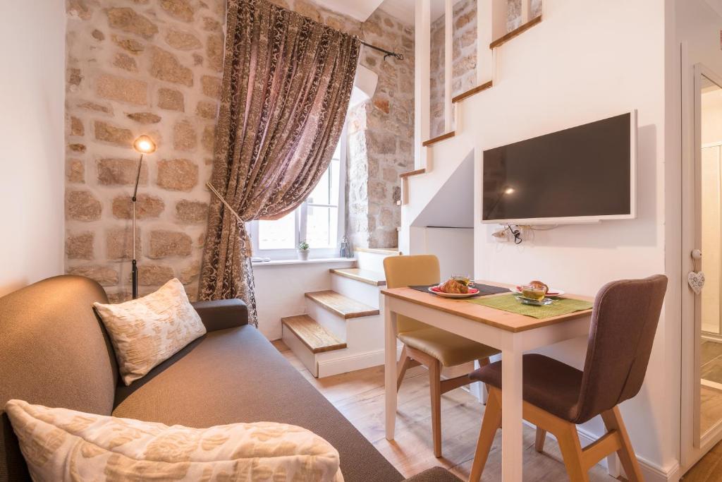 a small living room with a table and a couch at The St Blaise Swanky Collection in Dubrovnik