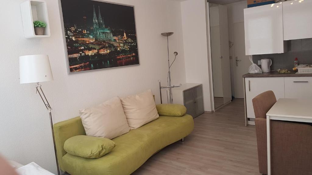 ケルンにあるSonniges Modernes Appartement Höhenbergのリビングルーム(黄色のソファ付)、キッチンが備わります。