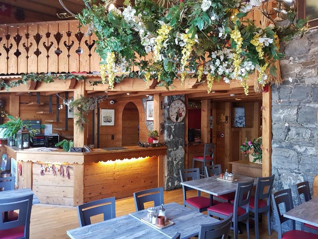 um restaurante com mesas e cadeiras e flores na parede em Hotel de Geneve em Genebra