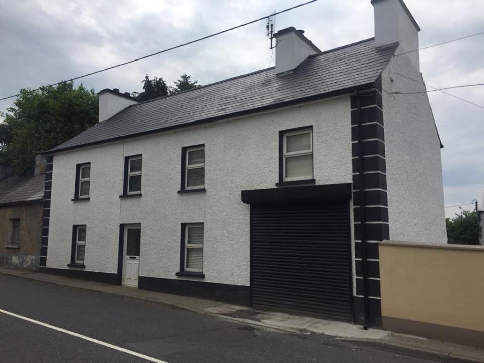 a white brick house with a garage at Sonny's Lodge in Donegal
